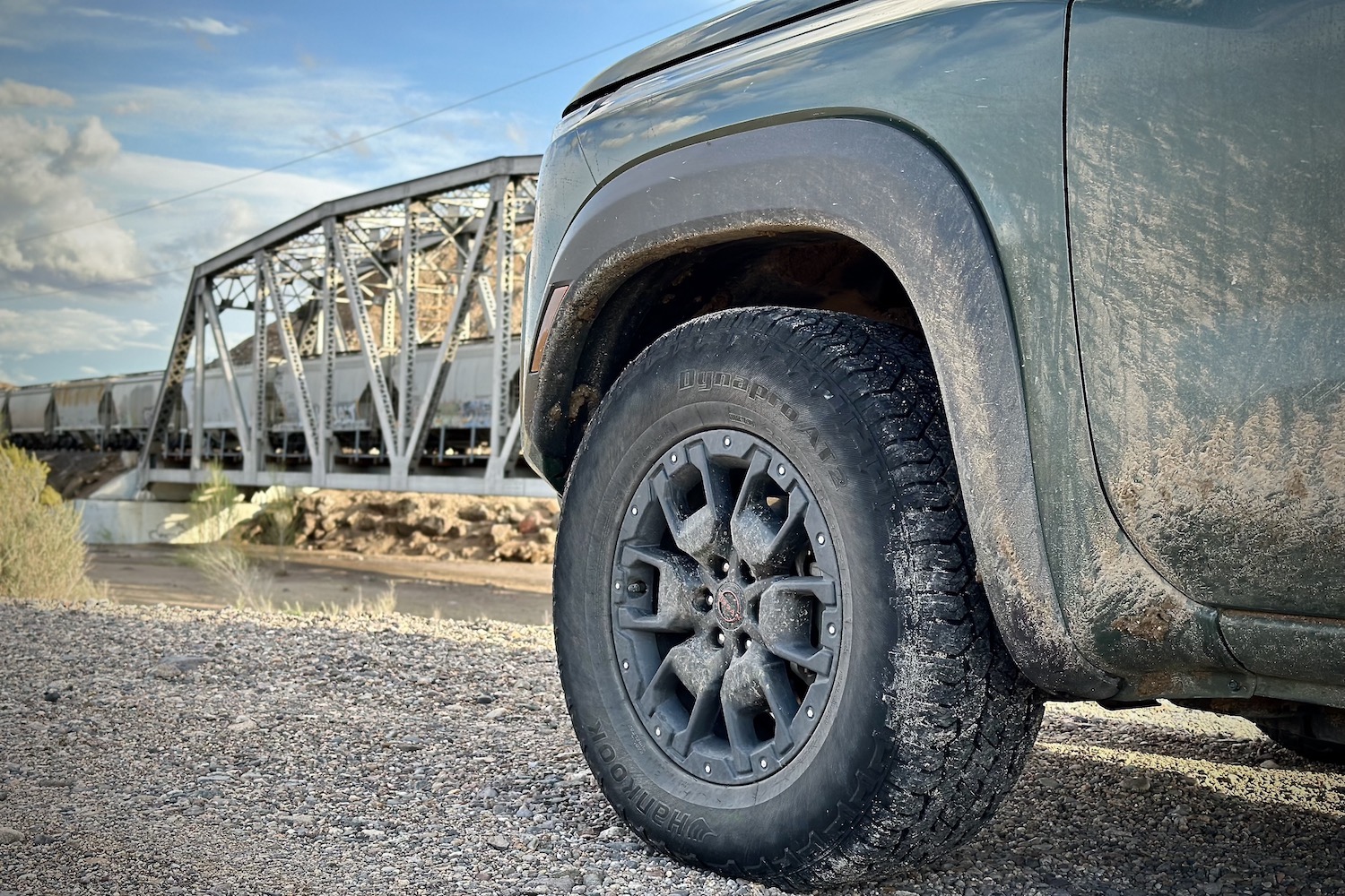 2022 Nissan Frontier Pro-4X close up of front tire on a dirt trail in front of a railroad track.