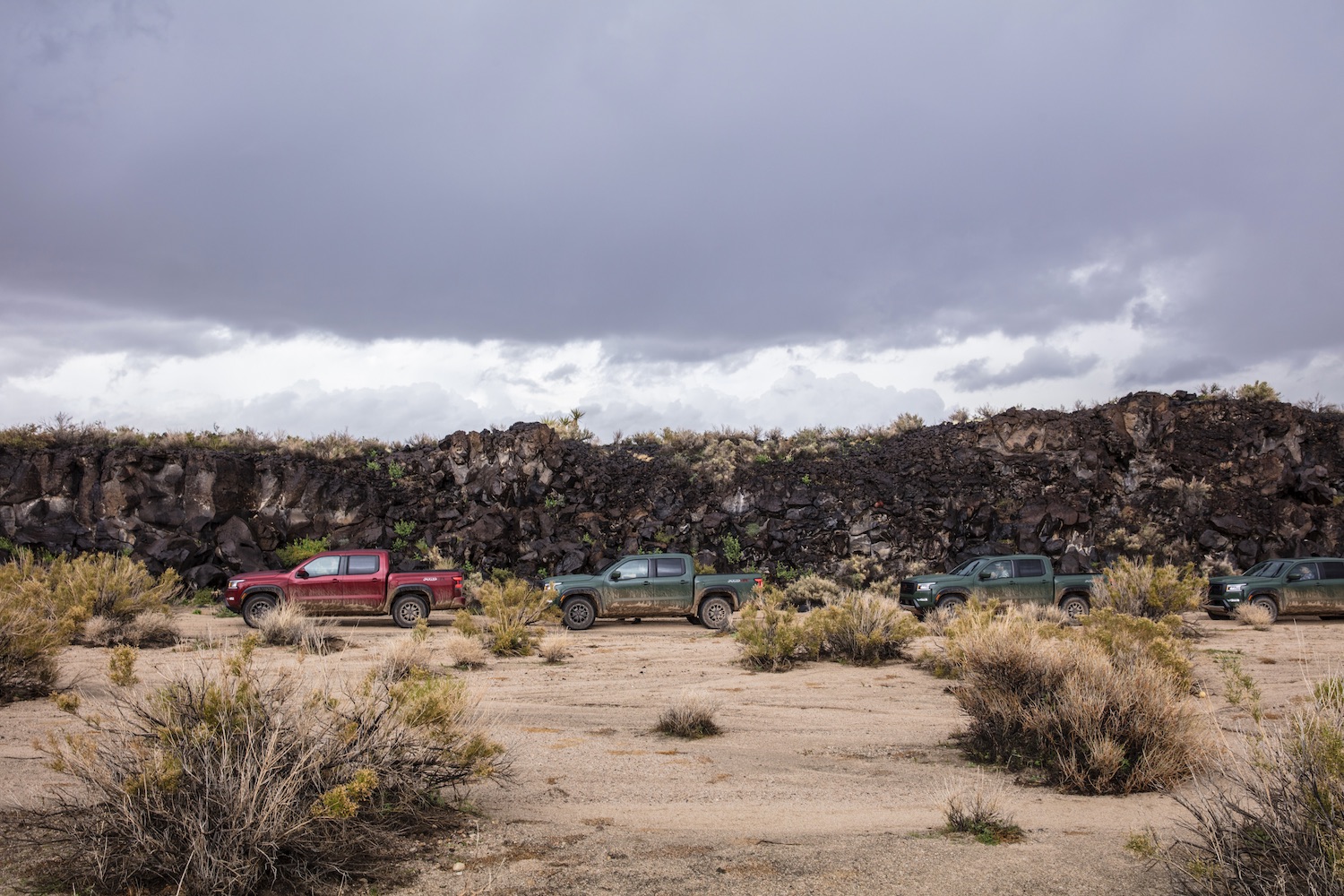 Side profile of 2022 Nissan Frontier Pro-4X parked in front of volcanic rocks.