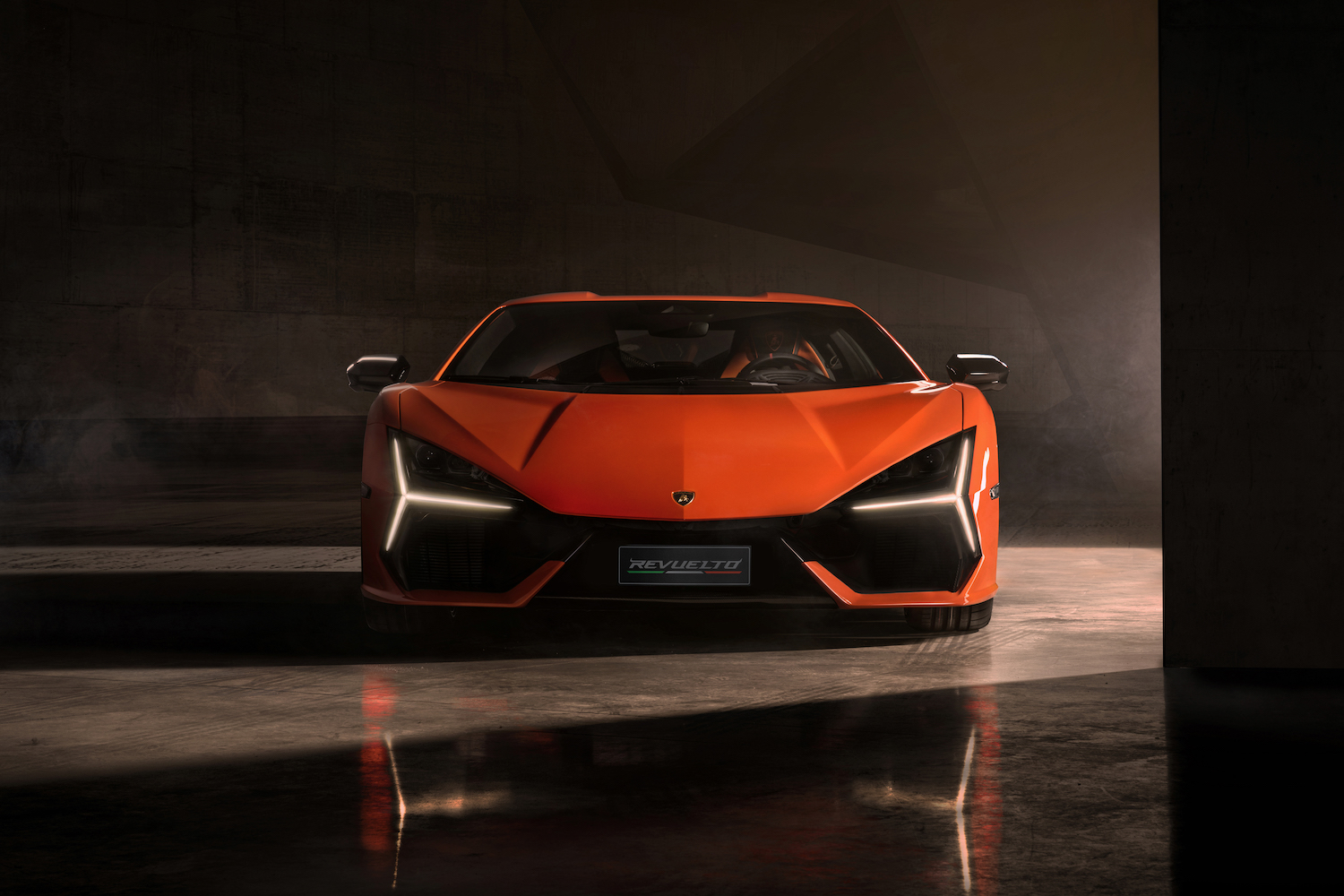 Close up of 2024 Lamborghini Revuelto parked in a studio with dramatic lighting.