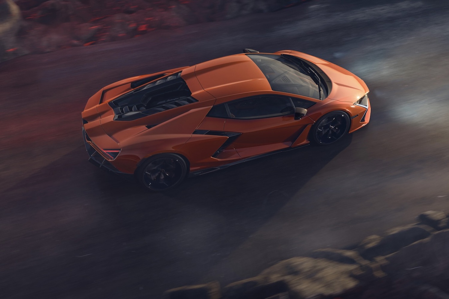 Overhead side profile of the 2024 Lamborghini Revuelto driving down the road.