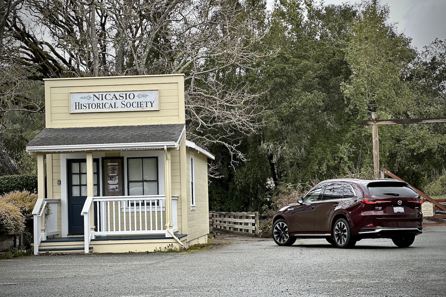 Side angle view of the 2024 Mazda CX-90 parked in front of an old building.