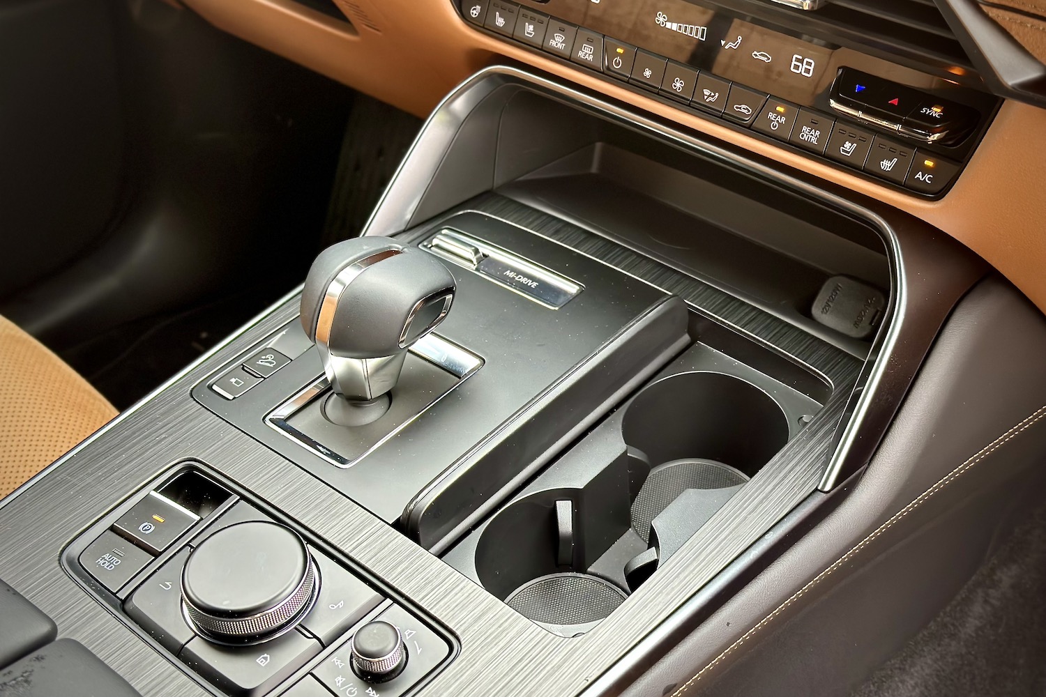 Close up of center console and gear shifter in the 2024 Mazda CX-90 from passenger's side.
