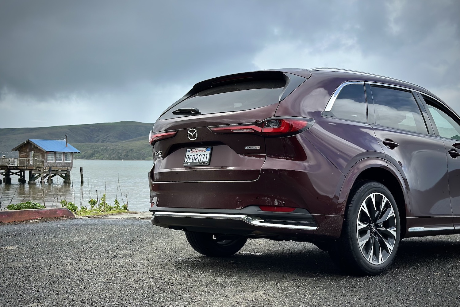 Close up of rear end of the 2024 Mazda CX-90 parked in front of a lake.