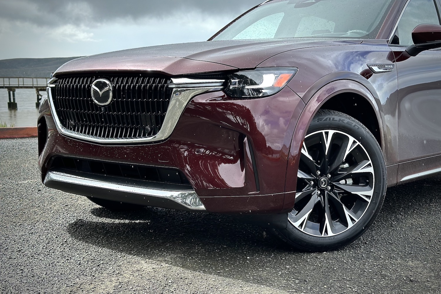 Close up of front end of the 2024 Mazda CX-90 from driver's side with dark clouds in the back.