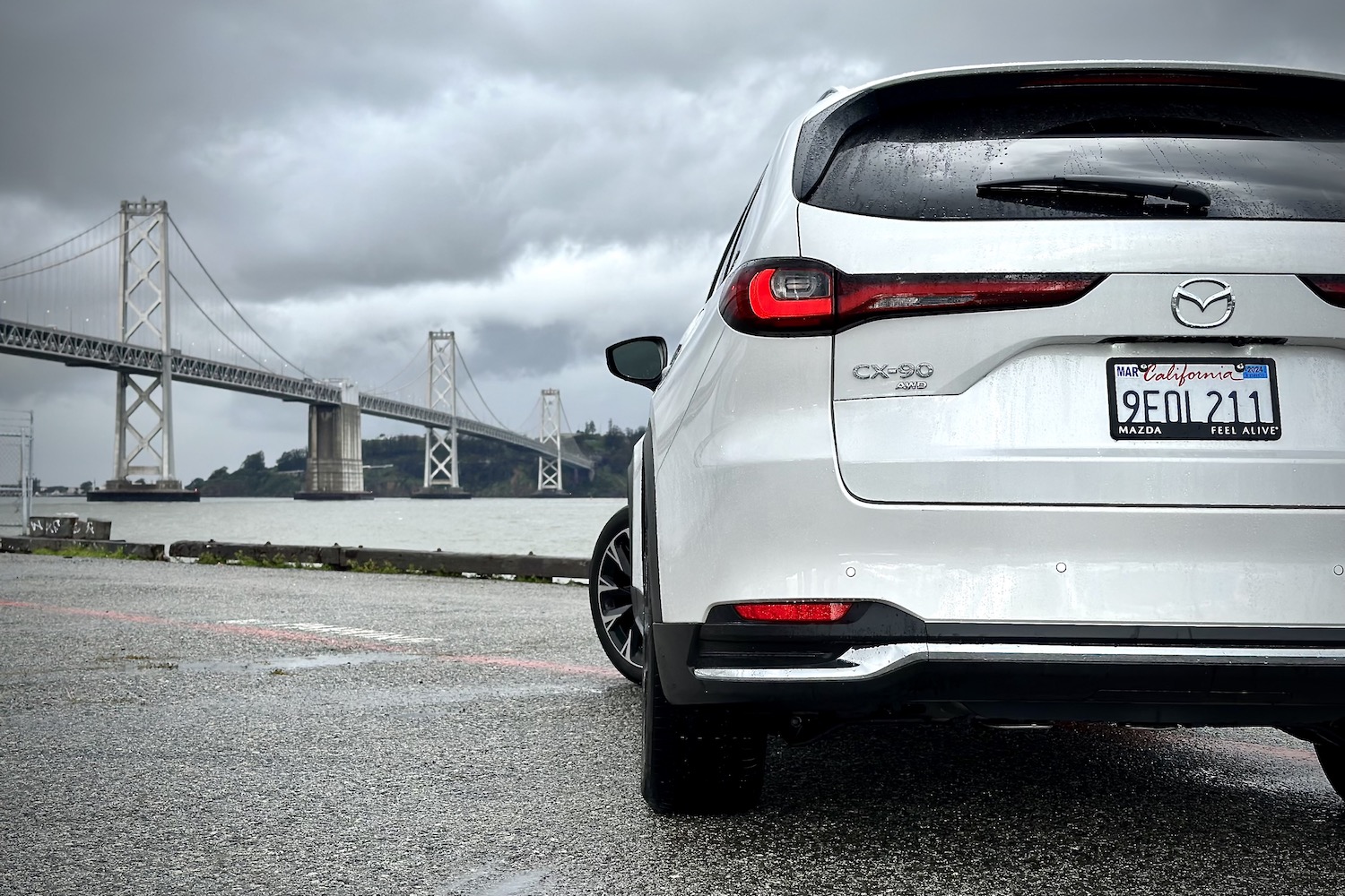 Close up of rear end of the 2024 Mazda CX-90 PHEV with a bridge in the back.