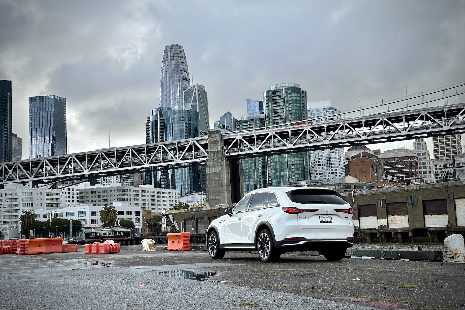 Rear end of the 2024 Mazda CX-90 PHEV parked in front of San Francisco city buildings.