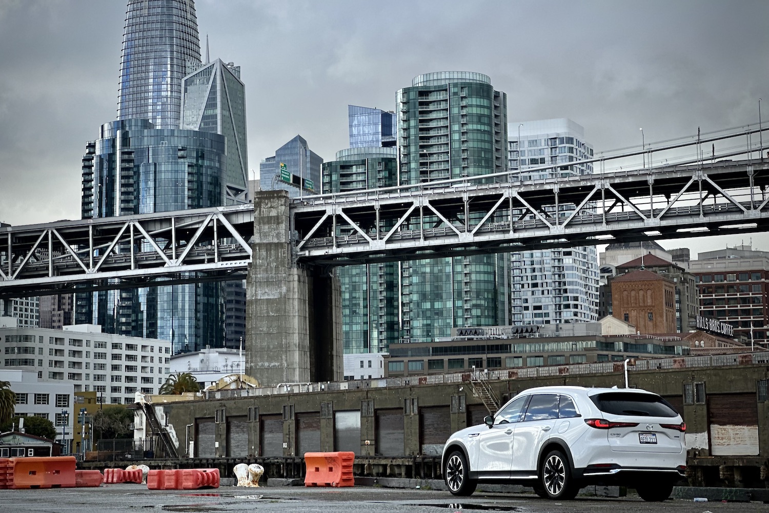 Rear end angle of the 2024 Mazda CX-90 PHEV parked in front of San Francisco city.