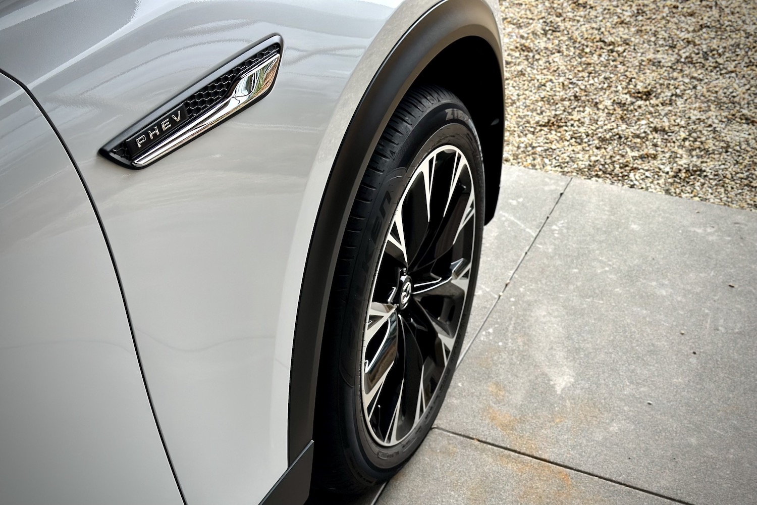 Close up of front wheel well in the 2024 Mazda CX-90 PHEV in a garage.
