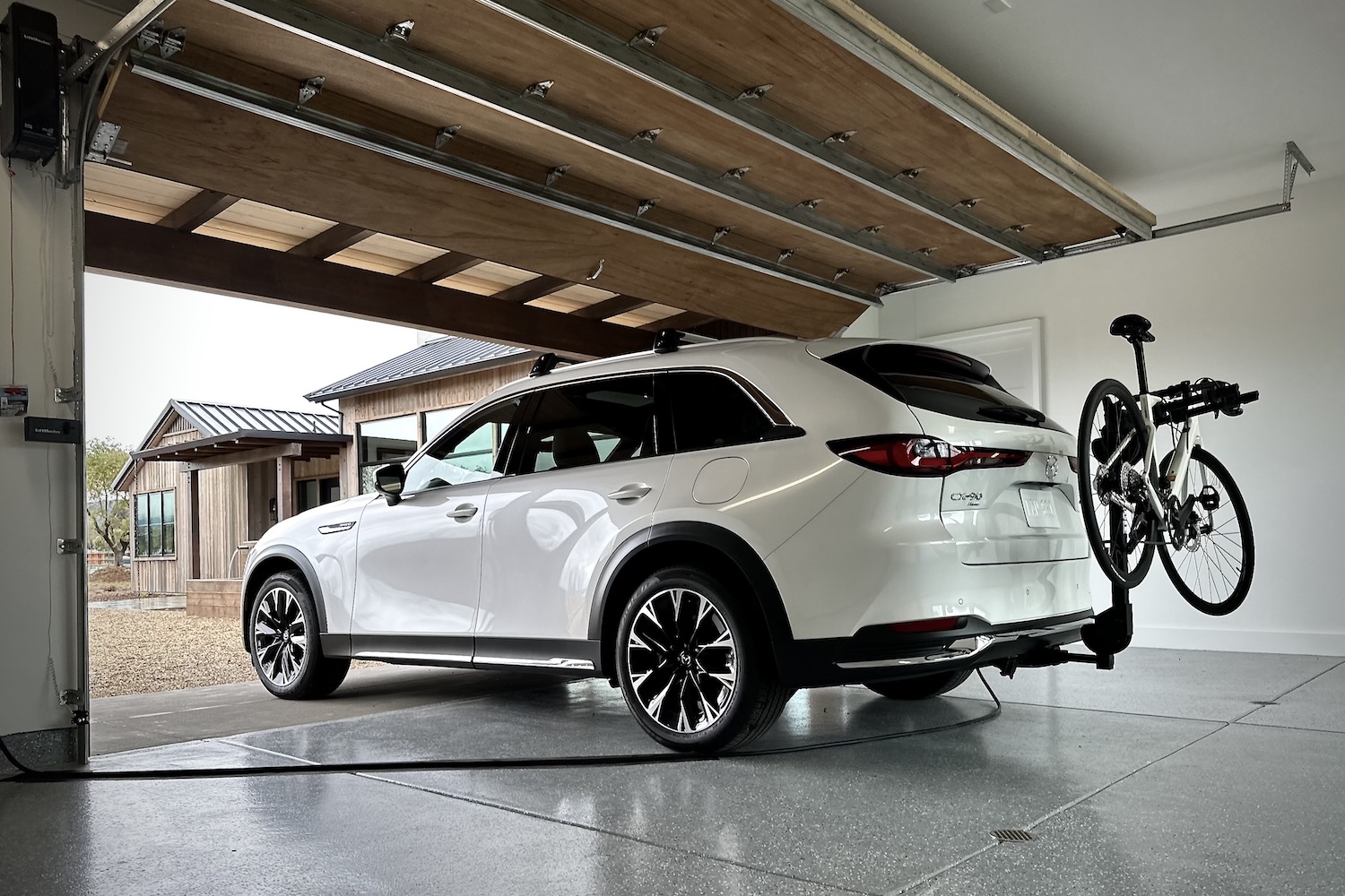 Rear end angle of the 2024 Mazda CX-90 PHEV parked in a garage.