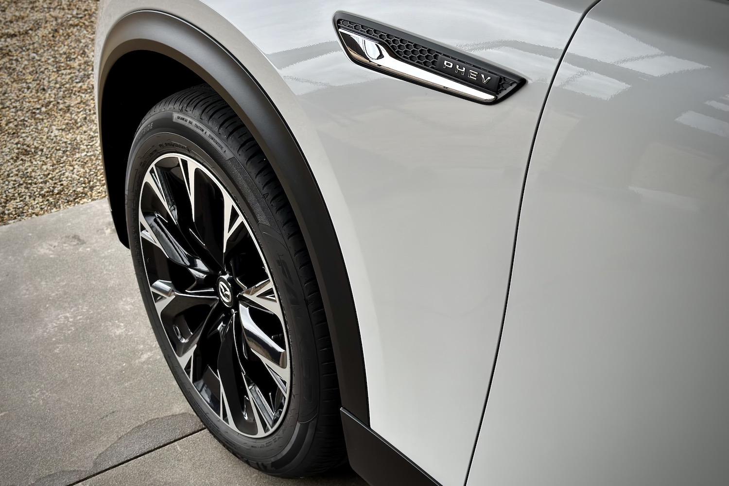 Close up of wheel well of the 2024 Mazda CX-90 PHEV parked in a garage.