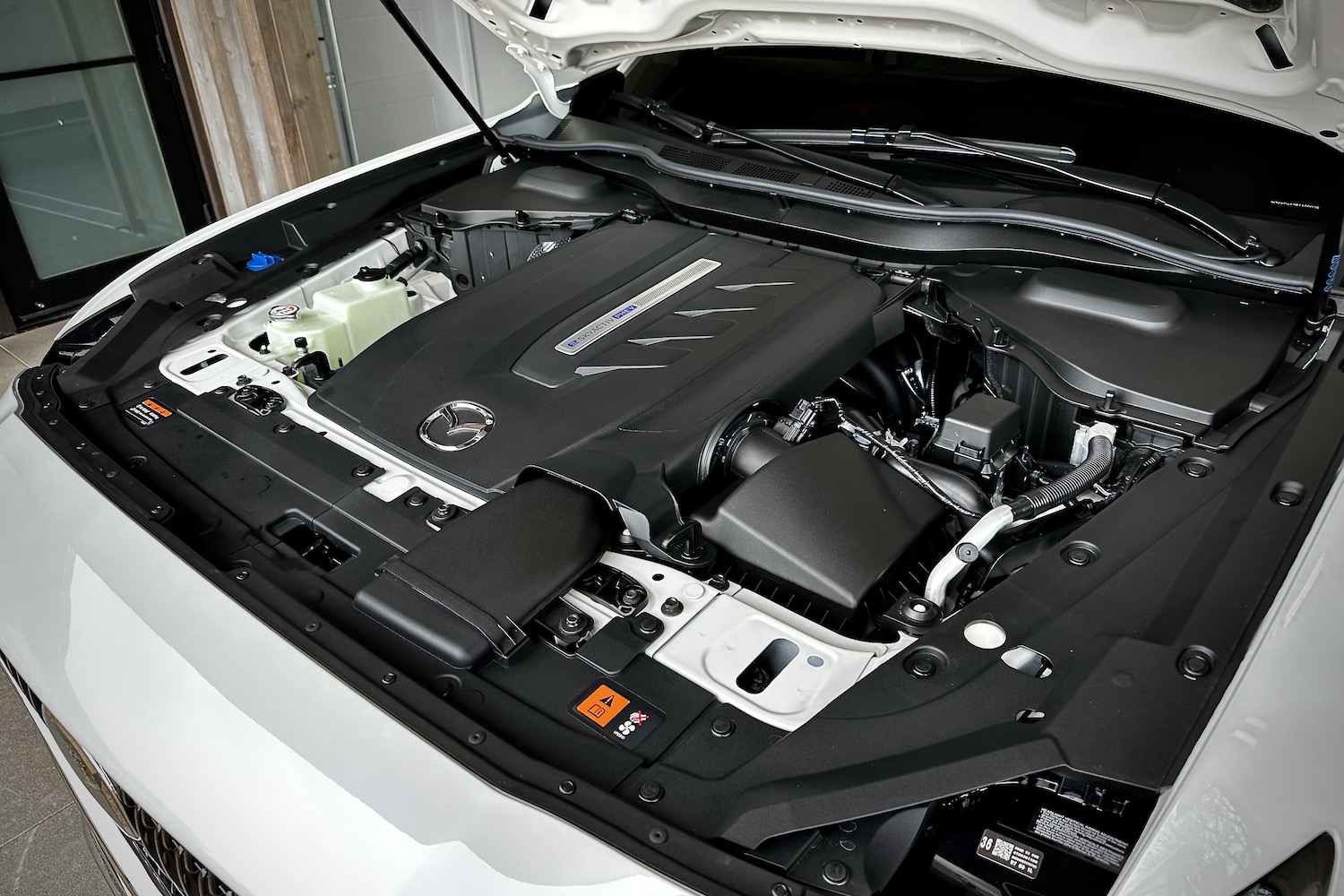 Close up of the engine in the 2024 Mazda CX-90 PHEV parked in a garage.