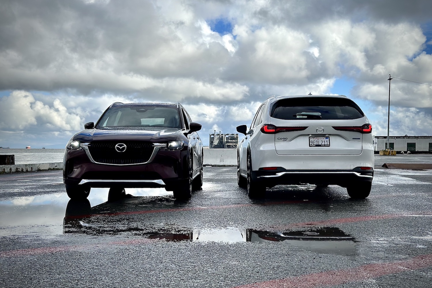 2024 Mazda CX-90 and PHEV front and rear end parked in front of dark clouds.