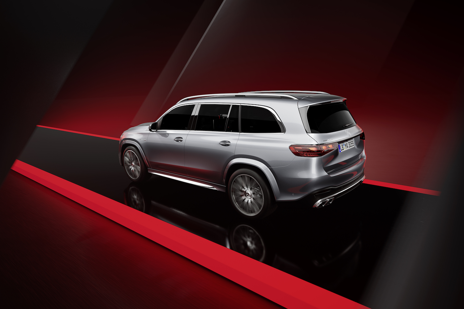 Rear end angle of the 2024 Mercedes-Benz GLS AMG 63 from the driver's side with a black and red background.