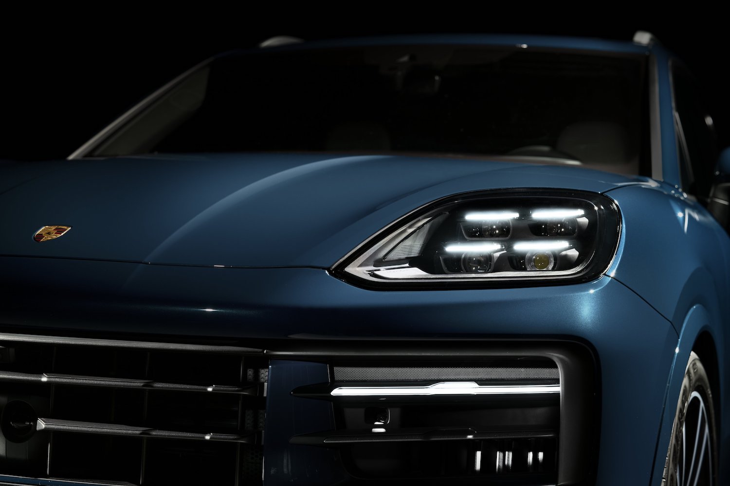 2024 Porsche Cayenne close up of headlights of an parked in a studio.