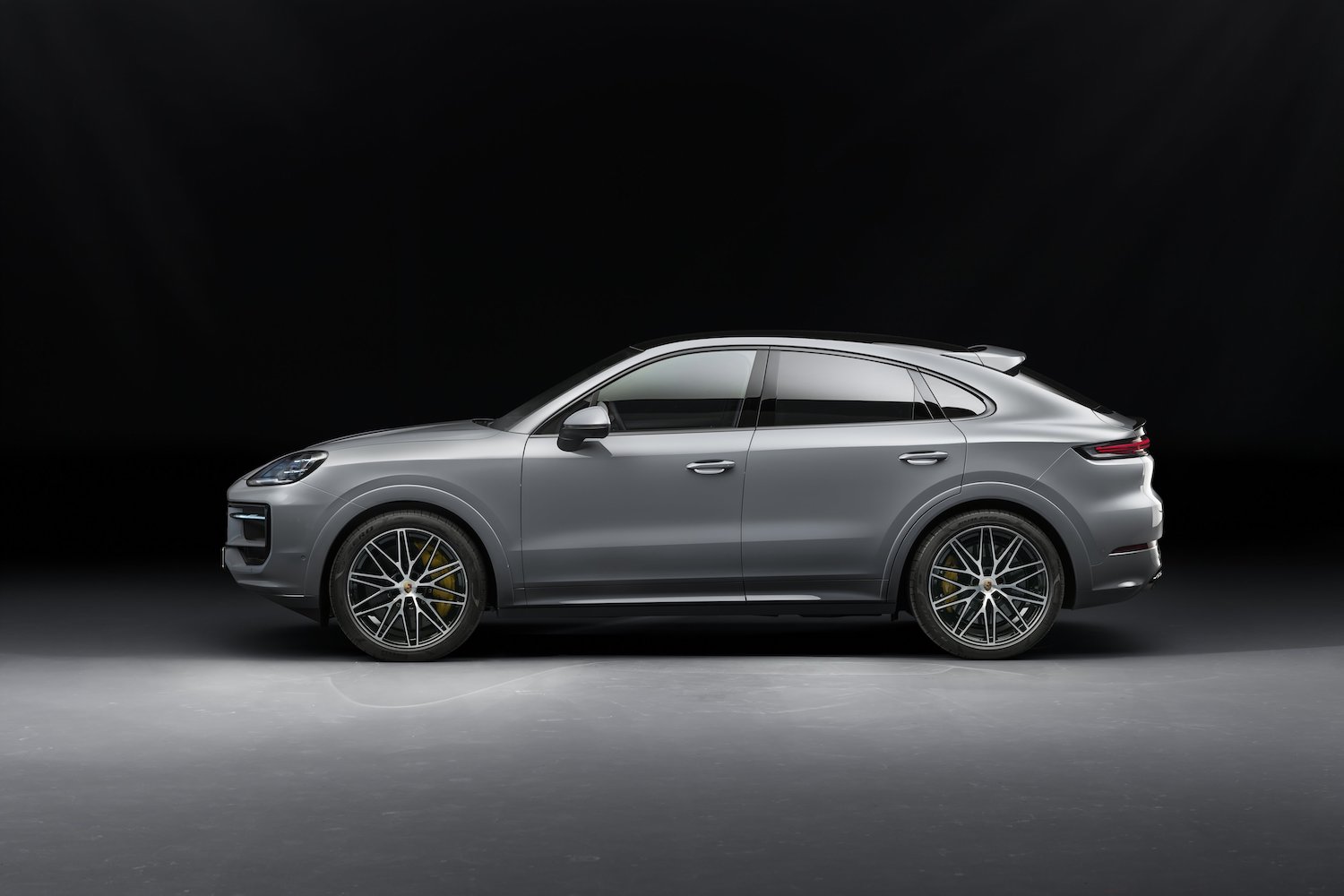 Side profile of the 2024 Porsche Cayenne S parked in a dark studio.