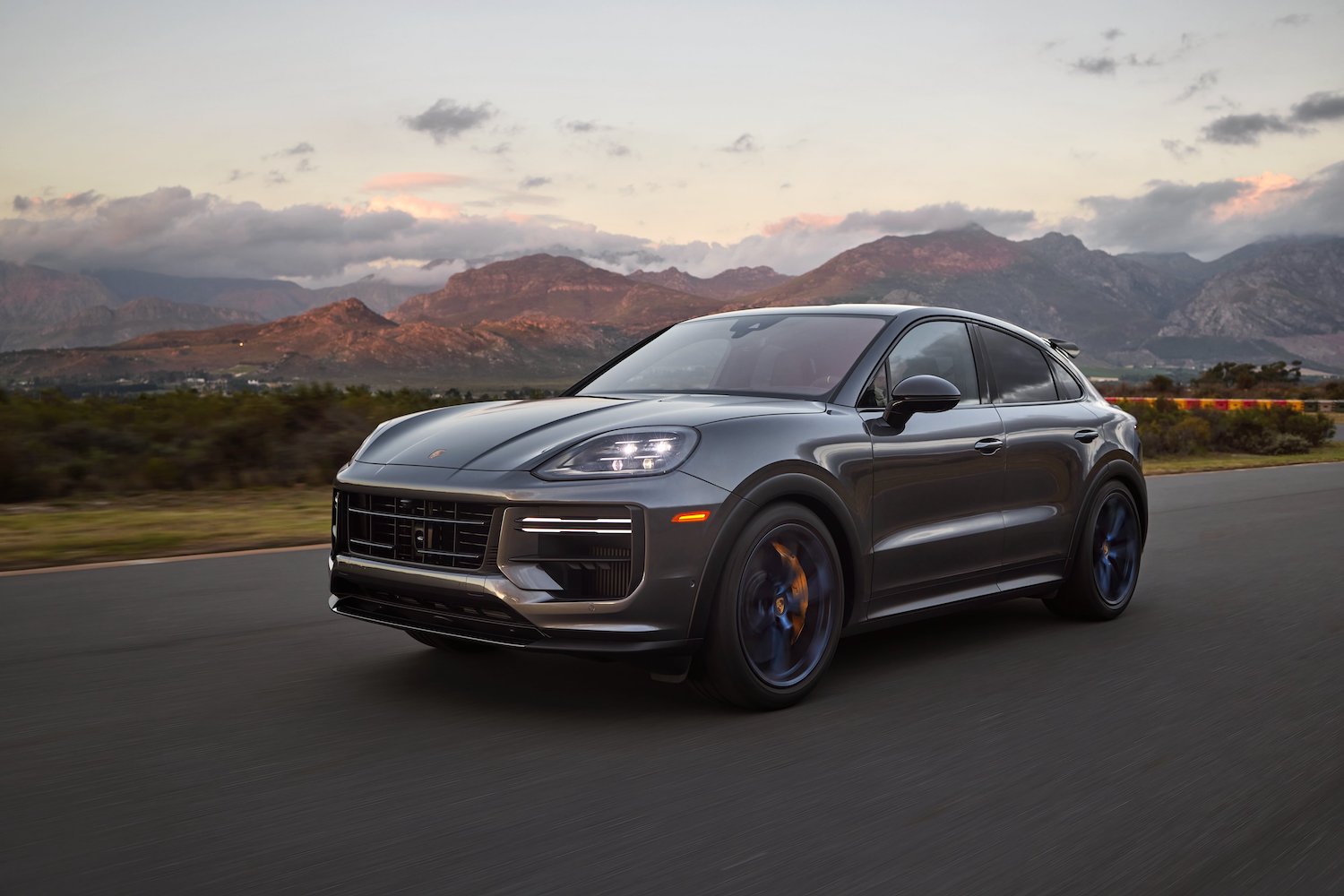 Front end angle of the 2024 Porsche Cayenne Turbo GT driving down the road.