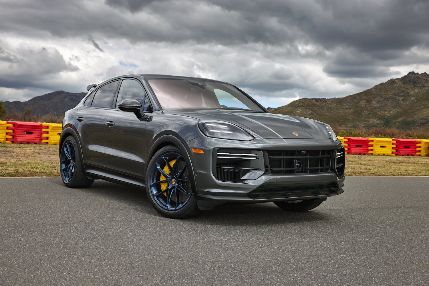Front end angle of the 2024 Porsche Cayenne Turbo GT parked in front of mountains.
