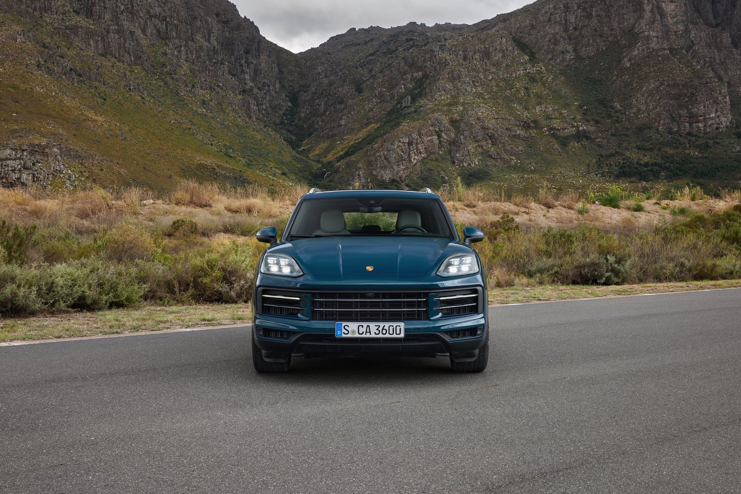 Close up of front end of the 2024 Porsche Cayenne parked in front of mountains.