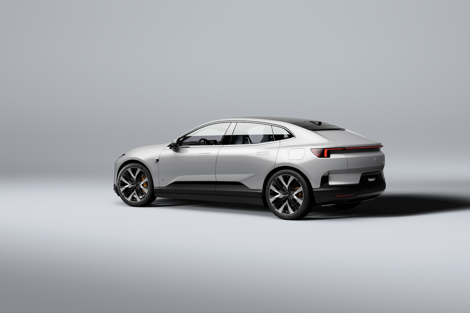 Rear end angle of the 2025 Polestar 4 from the driver's side in front of a white background.