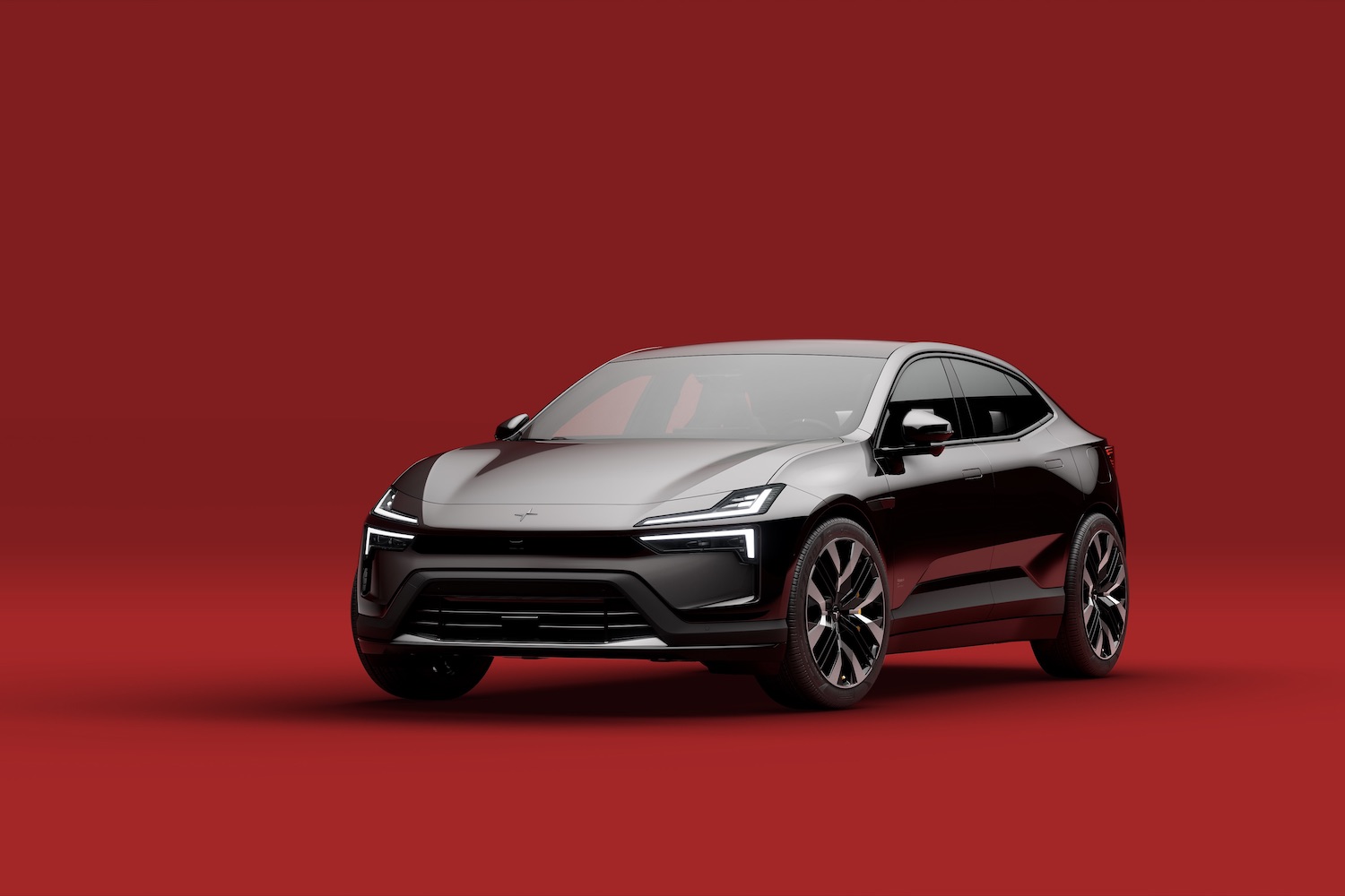 Front end angle of the 2025 Polestar 4 from the driver's side in front of a red background.