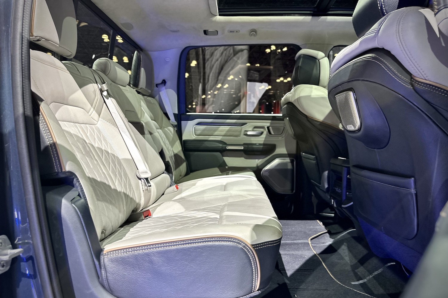 Rear seats in the 2025 Ram 1500 REV parked on a stage.