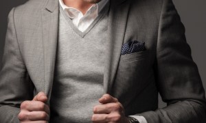 Man in a gray sweater and suit jacket
