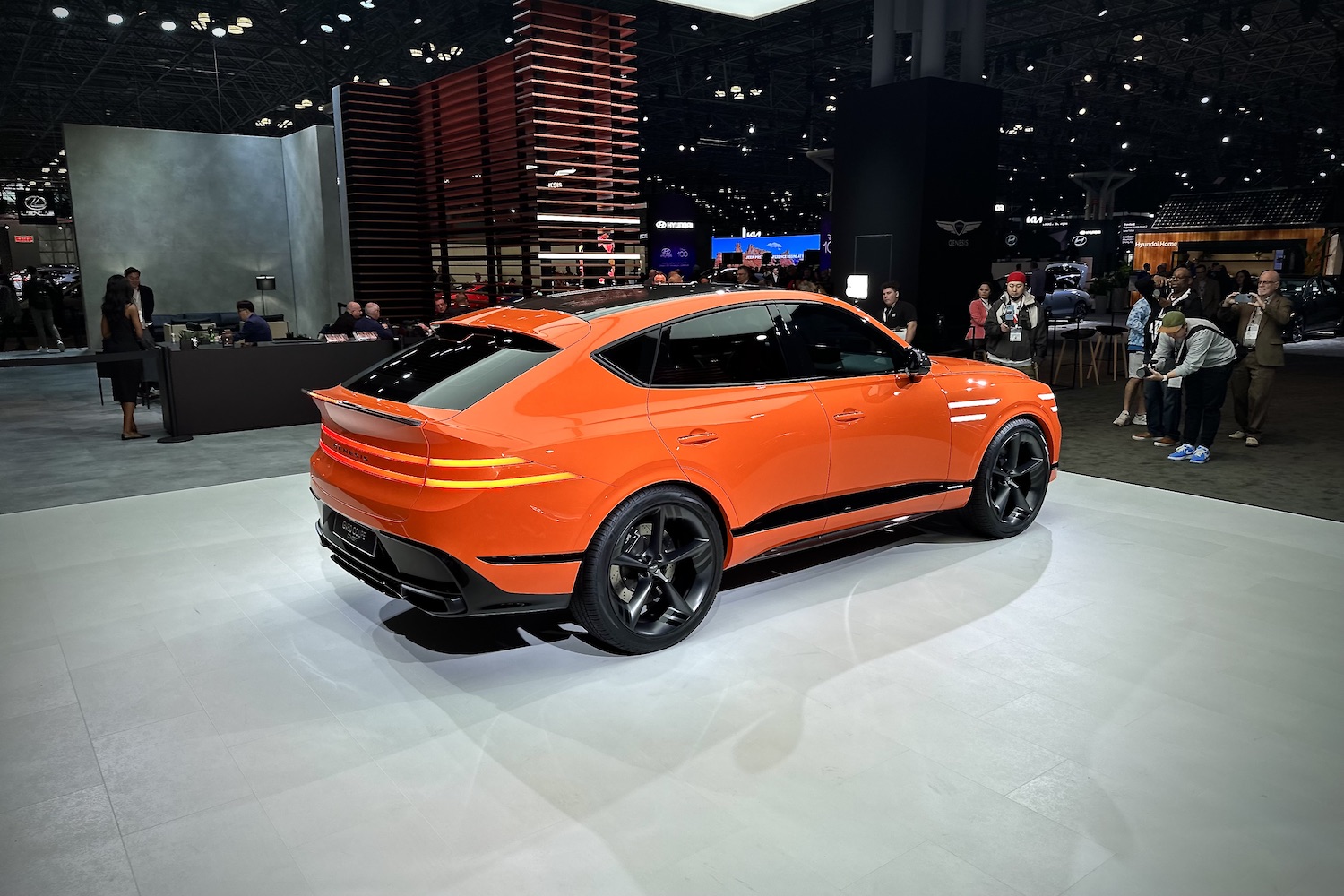 Rear end angle of the Genesis GV80 Coupe from the passenger's side parked on a stage.