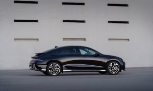 Hyundai Ioniq 6 side profile from the rear end parked in front of a building