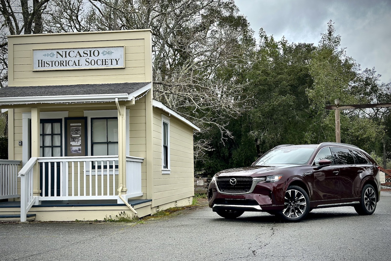 Front end angle of the 2024 Mazda CX-90 parked in front of an old building.