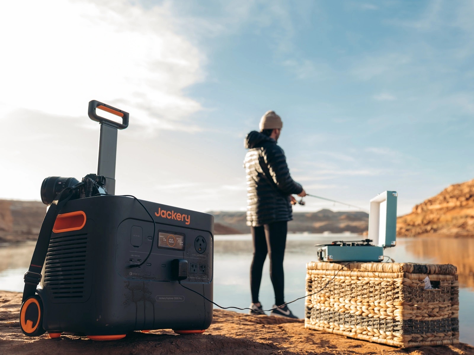 Person using Jackery portable power station outdoors while fishing.