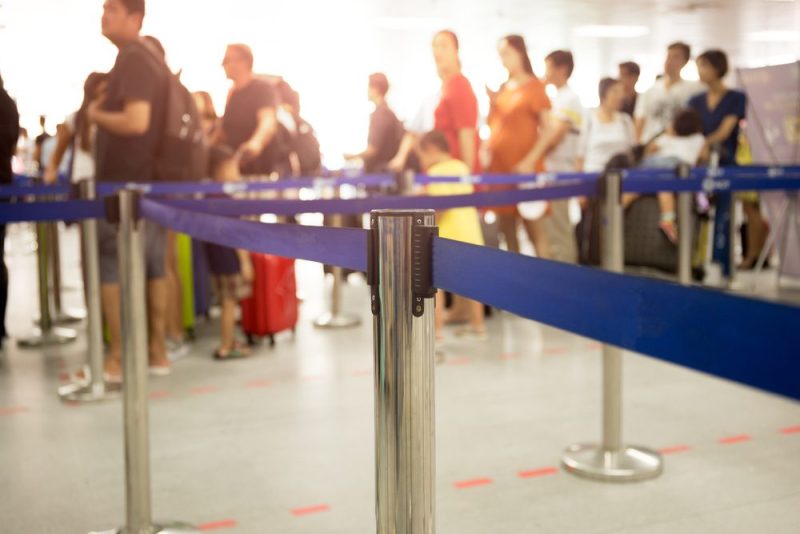 Airport security barriers with long line in background
