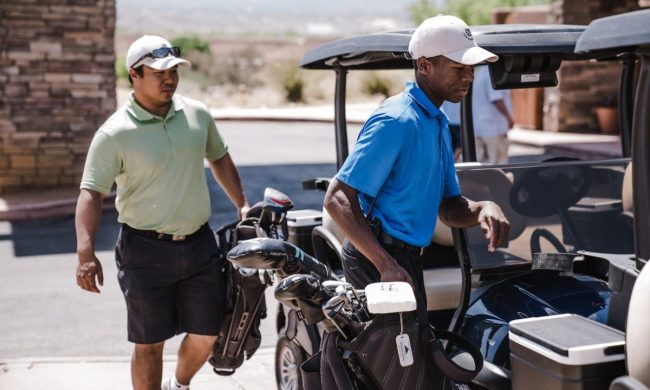 People loading their golf bags into the cart to start playing a round