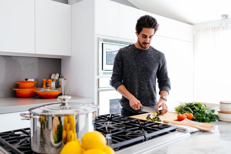 A person in the kitchen preparing the food to cook.