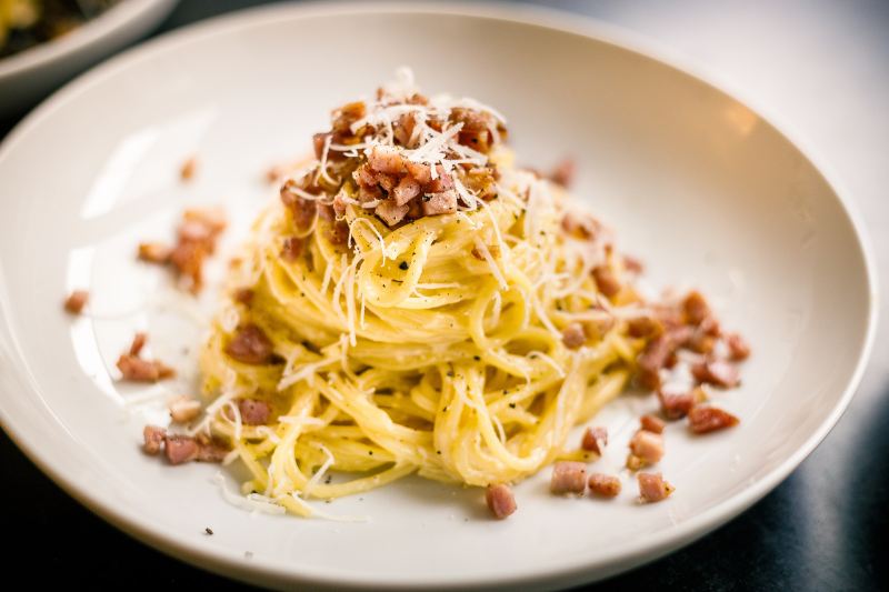 Pasta on white plate with cheese on top