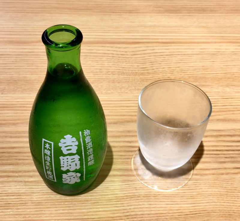 A sake set consisting of a green glass sake bottle and a short glass