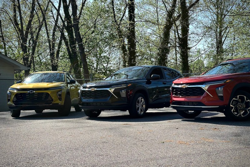 2024 Chevrolet Trax LS, 2RS, and Activ parked in a parking lot in front of trees.