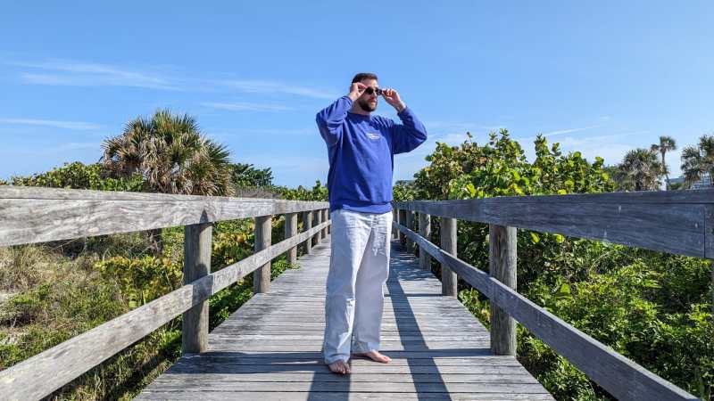 Man in Quicksilver Saturn Collection sweatshirt and pants on boardwalk