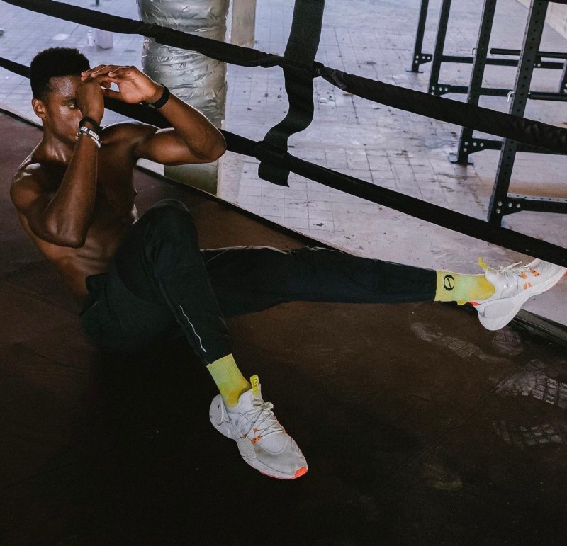 Nike trainer Joe Holder performing an ab crunch in a boxing ring.