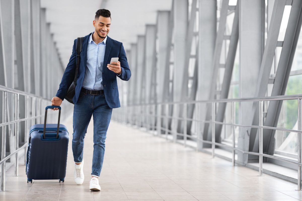 Hombre caminando por el aeropuerto con equipaje.