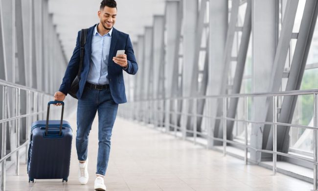 Man walking through airport with luggage.