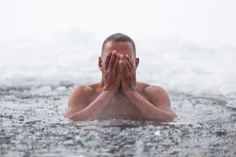 man swimming in ice