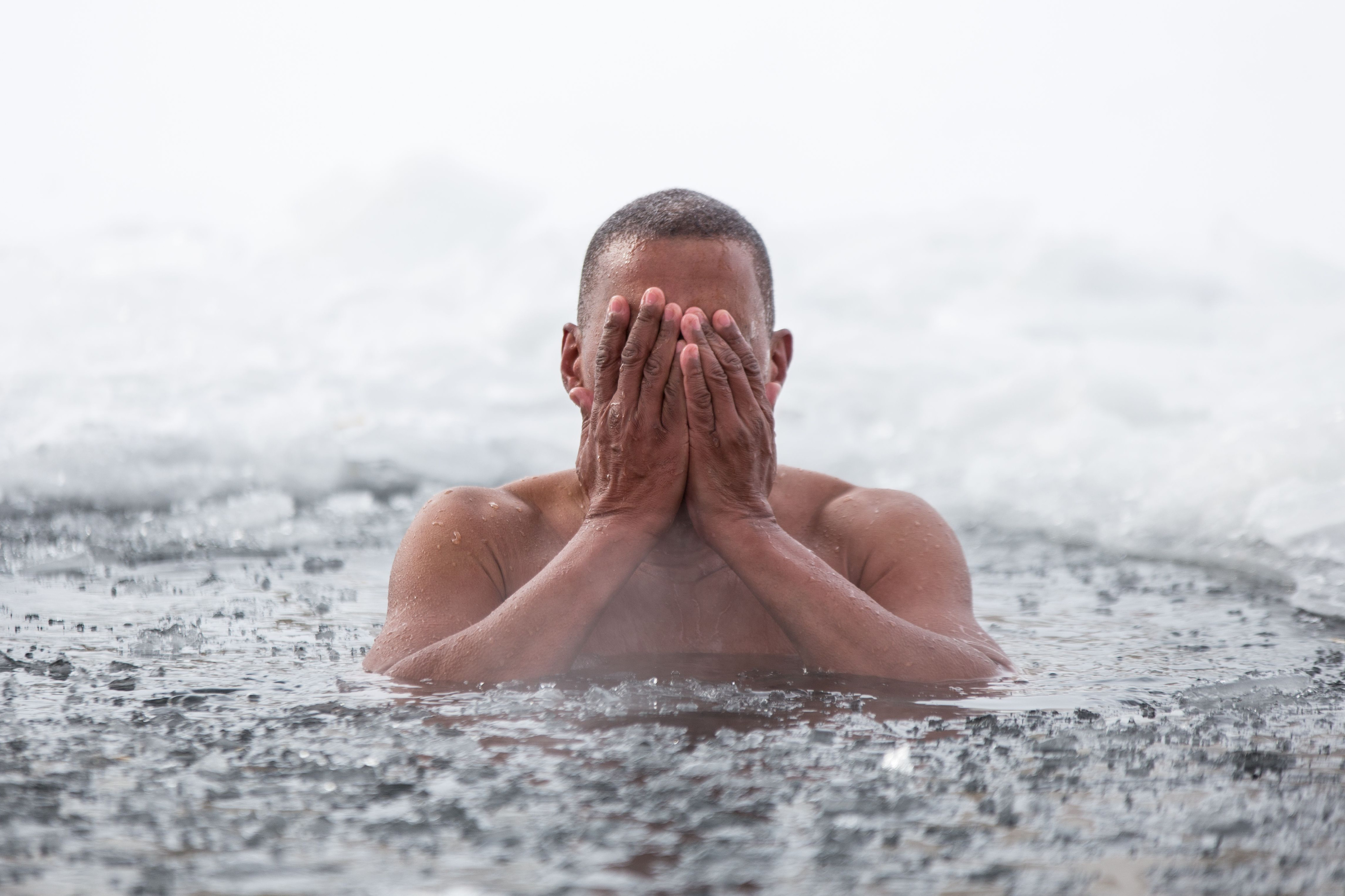 man swimming in ice