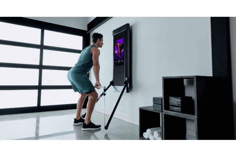 Man using the tonal at home gym in his living room.