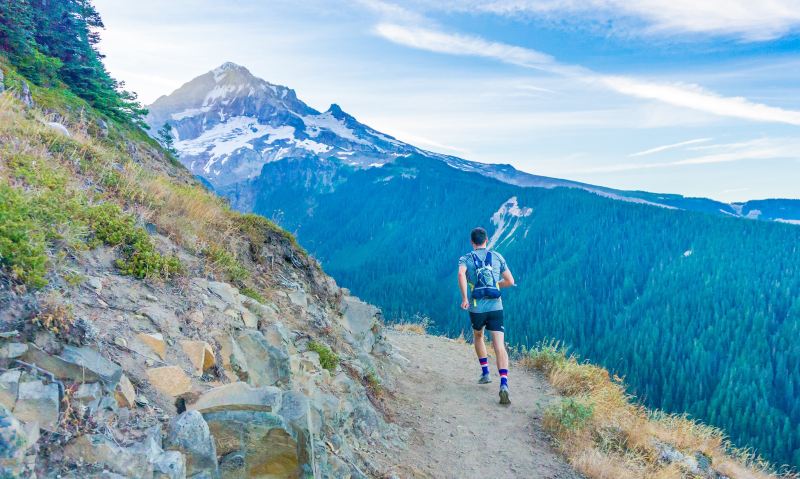 Trail runner jogging through mountains.