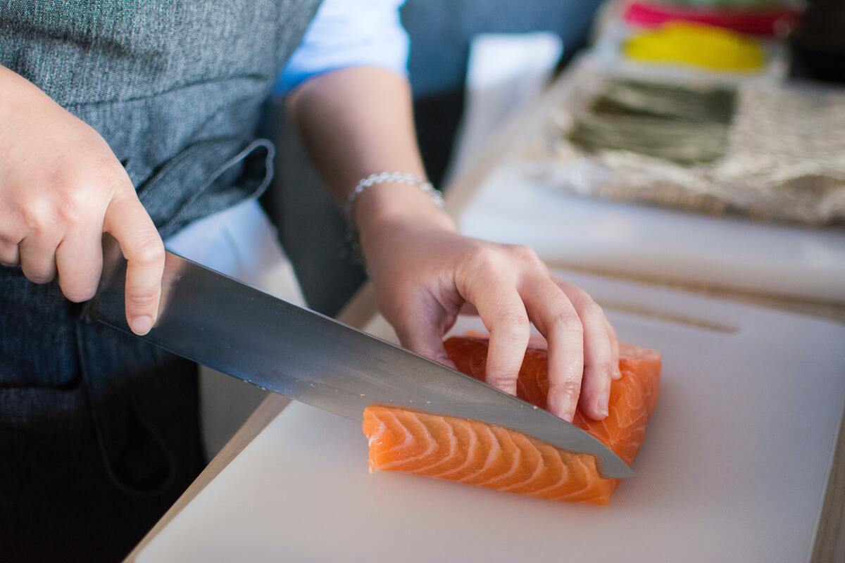 Person slicing salmon.