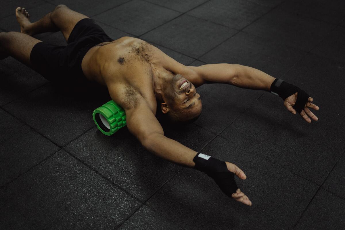 Man using foam roller on back.