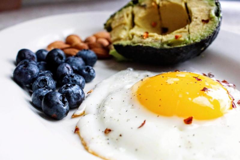 Un huevo, arándanos, almendras y aguacate.