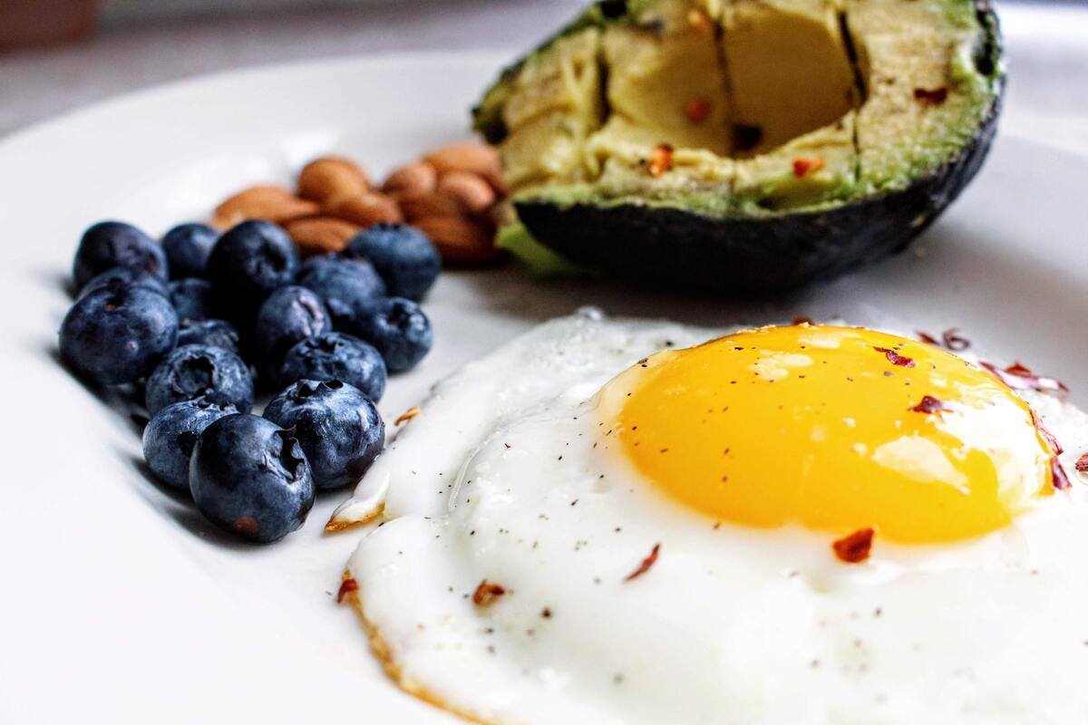 An egg, blueberries, almonds, and avocado.