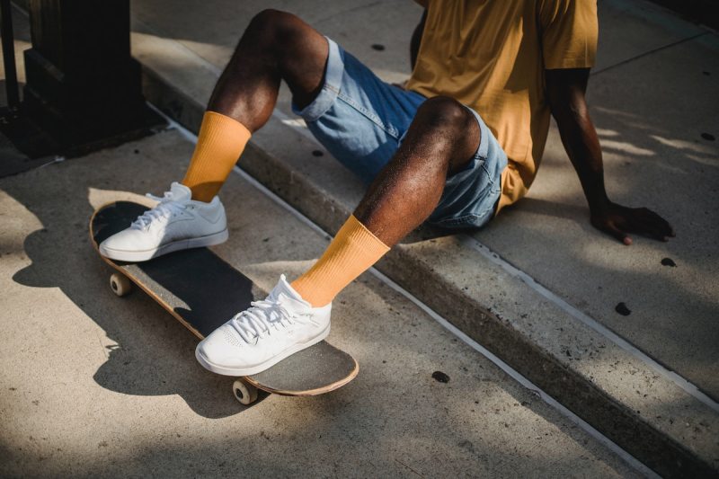 A man with white shoes on a skateboard