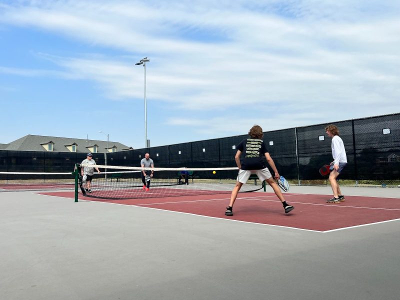 A group of people playing a game of pickleball.